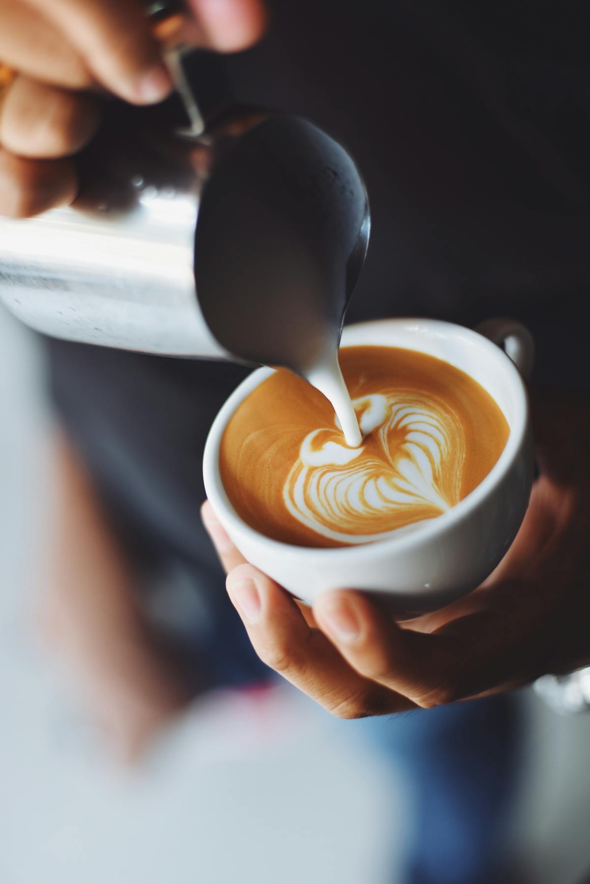 Milk being poured into a coffee to form latte art